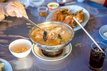 Blurred abstract background of hands eating on a table like seafood (Baked shrimp vermicelli, deep fried sea bass with fish sauce, yum squid) eaten alongside soft drinks, while on vacation with family