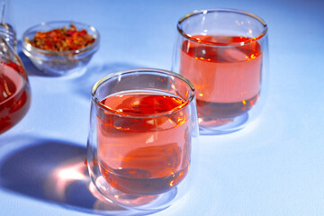 Two glass cups of tea on blue background