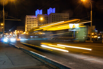 Fototapeta na wymiar The movement of a blurred bus along the overpass in the evening.