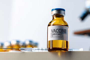 Covid-19 vaccine bottle with a syringe on lab table