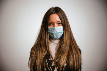 Potrait of young millennial beautiful woman with face mask for protection from infection by Coronavirus, Covid-19 - obrazy, fototapety, plakaty