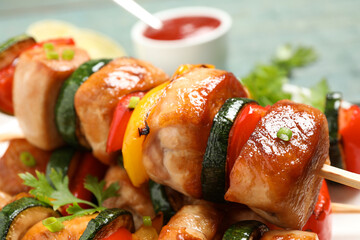 Delicious chicken shish kebabs with vegetables and parsley on plate, closeup