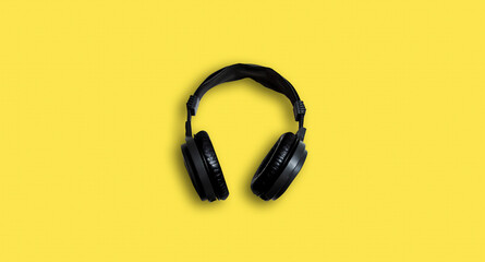 Fototapeta na wymiar black headphones on yellow bright background.
