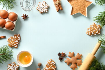 Christmas baking background with cookies and ingredients on blue background. Copy space. View from above.