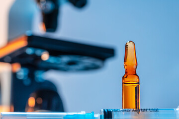Medical vial with medication near microscope photo