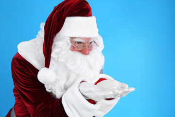 Fototapeta na wymiar Portrait of Santa Claus on light blue background
