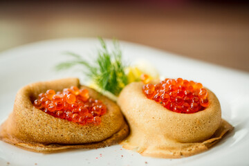 fresh pancakes with red caviar and oil