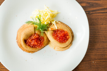 fresh pancakes with red caviar and oil