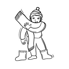 boy puts on boots and scarf, winter clothes