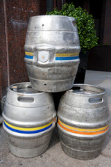 Three empty metal kegs outside a bar