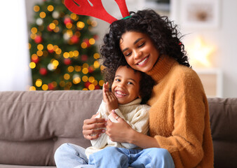 Mother and son playing and embracing on sofa on Christmas day.