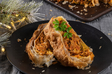 Puff pastry vegetable roll on kitchen table with christmas decorated