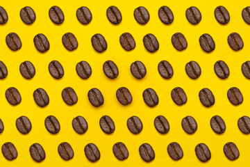 Diagonal pattern of coffee beans on yellow background
