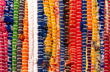 Background - a fragment of a rug made of multi-colored fabrics. Hand-made carpet.