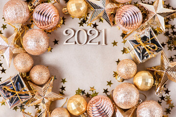 Wooden numbers 2021 on a paper background with shiny golden Christmas balls, glitter stars....