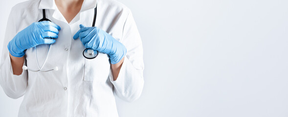 Doctor in a lab coat and surgical gloves with stethoscope over white background.