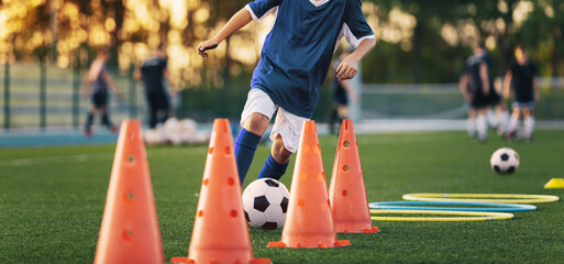 Football Player on Training Slalom Drill With Ball. Soccer Boy Running Between Red Training Cones...