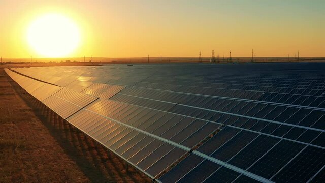 Drone footage of a solar power plant at sunset