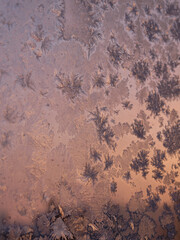 Background image. Frost patterns on glass. Dawn. Orange and pink tones.