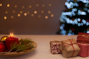 A Christmas arrangement, gifts, colored lights, candles and snow in the environment