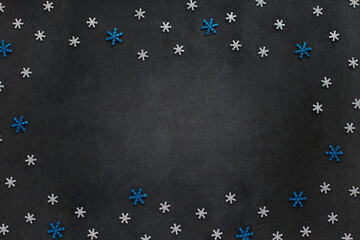 Dark Christmas and New Year background with cutted glitter silver and blue snowflakes