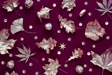 Autumn flat lay, top view with painted golden leaves on dark red, brown textured background. Dark luxury design with metallic Fall leaves..