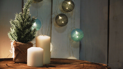 Small Christmas tree and candles on a wooden background