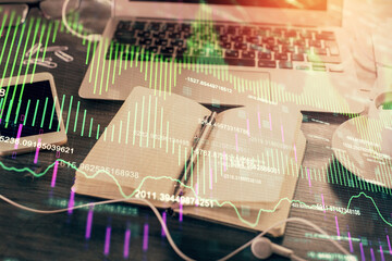 Multi exposure of financial graph drawings and desk with open notebook background. Concept of forex