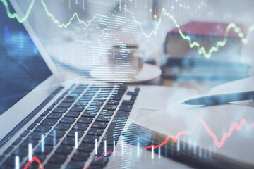 Double exposure of financial chart drawing and desktop with coffee and items on table background. Concept of forex market trading