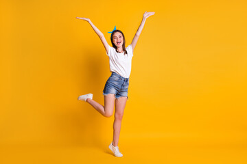 Fototapeta na wymiar Full length body size view of lovely cheerful brown-haired girl jumping having fun isolated over bright yellow color background