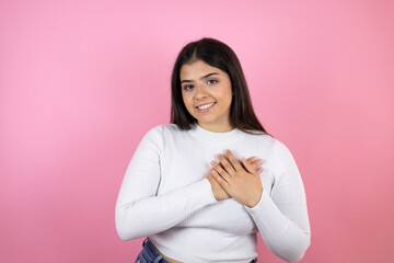 Young beautiful woman over isolated pink background smiling with her hands on her chest and grateful gesture on her face.