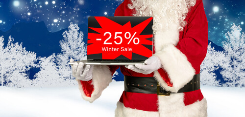 santa claus holds laptop in hand with 25 percent winter sale advertising