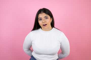 Fototapeta premium Young beautiful woman over isolated pink background afraid and shocked with surprise and amazed expression, fear and excited face.