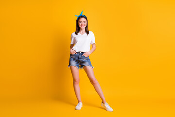 Fototapeta na wymiar Full length photo of nice cheerful girl wear casual outfit pose hold hands in pockets isolated on bright yellow color background