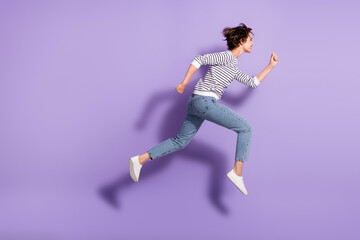 Fototapeta na wymiar Full length photo of pretty shiny lady dressed casual clothes jumping running straight isolated purple color background