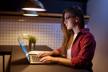 Concentrated girl student in glasses watching online webinar courses and communicate by conference...
