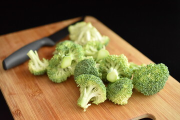 Green organic not cooked broccoli, close-up, over black background.