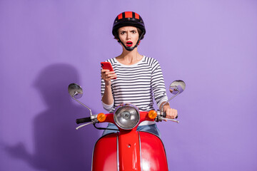 Photo of confused upset lady ride scooter hold telephone open mouth wear helmet striped shirt...