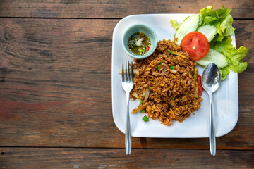 fried rice with pork on wooden table, Thai cuisine.