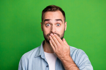 Portrait of scared guy hand lips wear blue shirt isolated on vibrant green color background