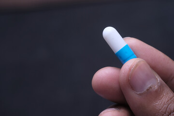 Close up of hand capsule on black background 