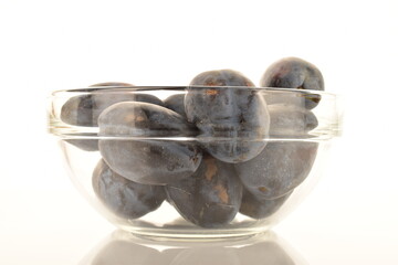 Several ripe organic Damson plums, close-up, isolated on white.