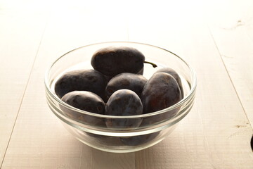 Several ripe organic Damson plums, close-up, isolated on white.