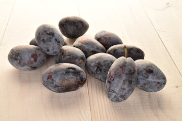 Several ripe organic Damson plums, close-up, isolated on white.