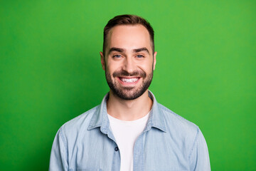 Obraz premium Portrait of optimistic funny man wear blue shirt isolated on green color background