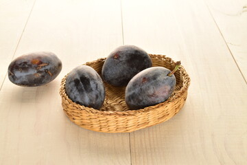 Several ripe organic Damson plums, close-up, isolated on white.