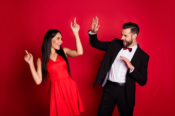 Photo of nice optimistic couple dancing wear suit dress isolated on red color background