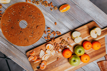 Grape fruit leather with nuts on the wooden table. Round fruit leather. Healthy food. Apples, bananas, grape top view. Grape fruit without sugar.
