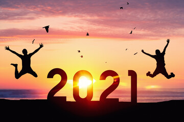 Silhouette men jumping and birds flying on sunset sky at top of mountain and number like 2021 abstract background. Happy new year and holiday celebration concept. Vintage tone filter color style.