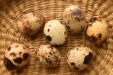 Obraz premium Quail eggs, close-up, on a straw mat.